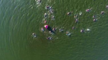 ironman triatlon yarışında yüzücülerin havadan yukarıdan aşağıya su üzerinde kırmızı şamandıra bypass
