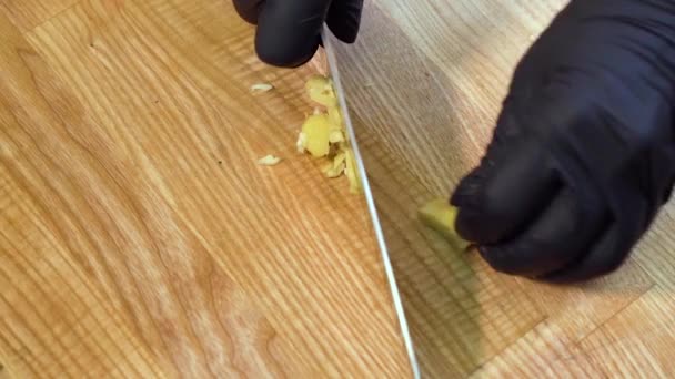 Z góry na dół zbliżenie kucharz ręce cięcie korzenia imbiru na drewnianej deski do krojenia — Wideo stockowe