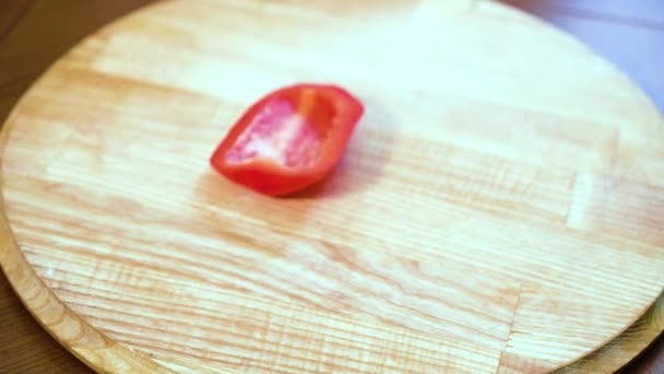 Gros plan de mains de chef en gants tranchant poivron rouge sur planche à découper en bois — Video