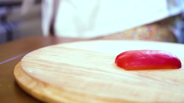 Primer plano de la cacerola de chef manos rebanando pimiento dulce rojo en tabla de cortar de madera — Vídeo de stock