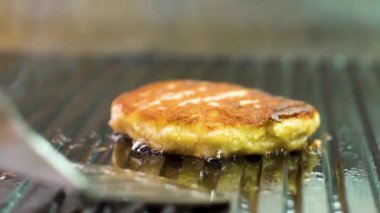 spatula ile ızgara pişmiş burger alarak siyah eldiven şef el closeup