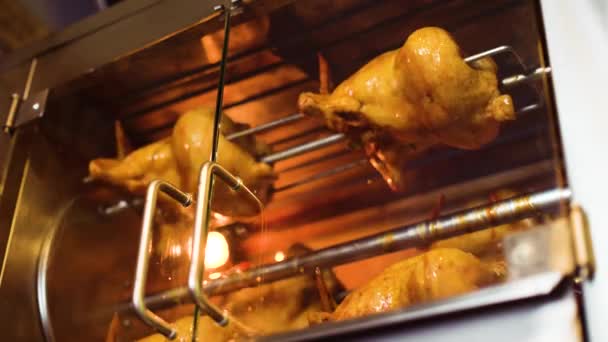 Tiro de baixo ângulo de rotisserie com frango inteiro girando lentamente nele — Vídeo de Stock