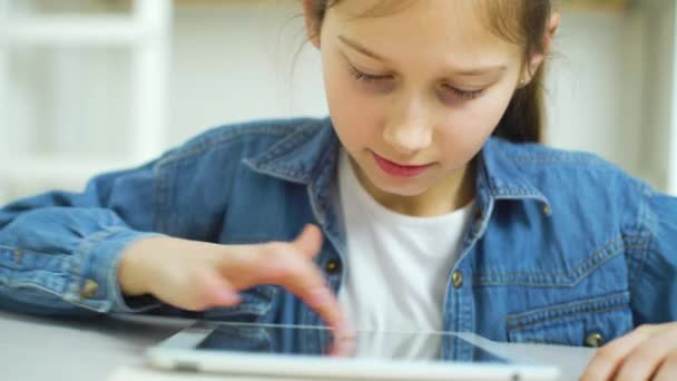 Gros plan de petite fille jouer à des jeux en ligne sur tablette — Video