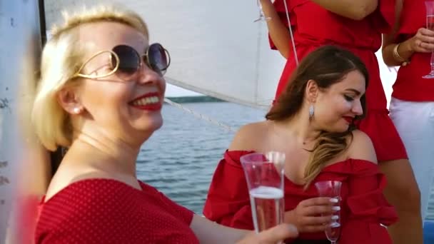 Mujeres en trajes rojos disfrutando de viaje en velero — Vídeo de stock