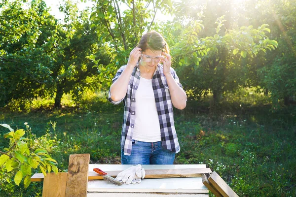 Žena v pracovním oblečení nasadit ochranné brýle — Stock fotografie