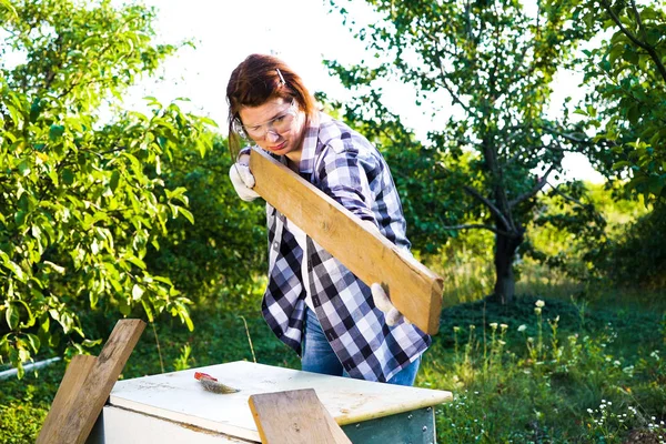 Kvinnlig snickare kontroll jämnhet av trä planka — Stockfoto