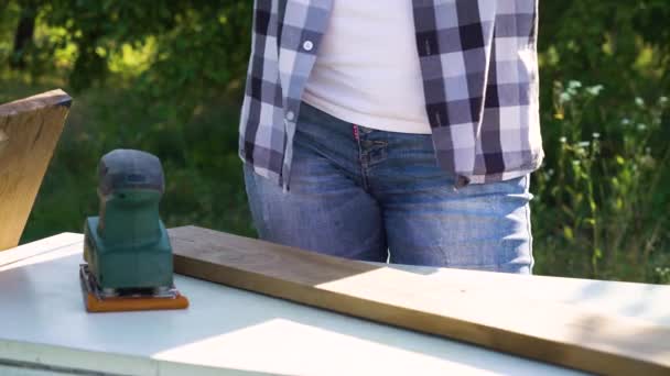 Bijgesneden schot van de vrouw in beschermende handschoenen polijsten plank met elektrische schuurmachine — Stockvideo