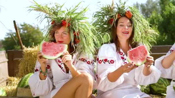 Kvinnor i etniska kostymer äta vattenmeloner utanför — Stockvideo