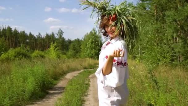 Дівчина в етнічній сукні і квітковому кільці запрошує слідувати за нею зовні — стокове відео