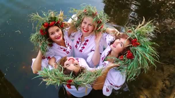 Vier vrouwen in florale circlets staan in water — Stockvideo