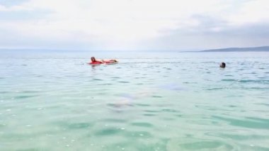 genç kızlar yüzme şilteve dalış maskeleri üzerinde deniz banyosu keyfini çıkarın