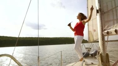 Yelkenli teknede duran yazlık elbiseli kadın