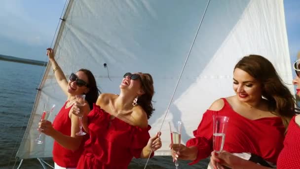 Vrouwen in rode kleren toasten met wijn op zeilboot partij — Stockvideo