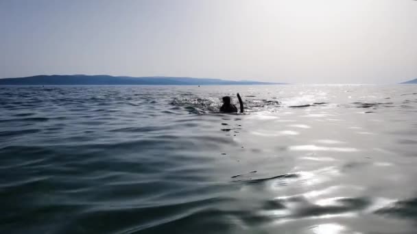 ダイビングマスクとシュノーケルで海底を探索する少女のシルエット — ストック動画