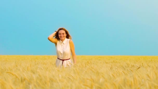 Heureuse fille aux cheveux rouges courir dans le champ de blé doré — Video