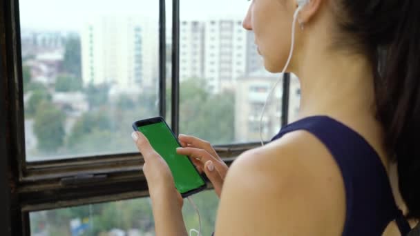 Genç kadın smartphone cep telefonu ile müzik dinlemek — Stok video