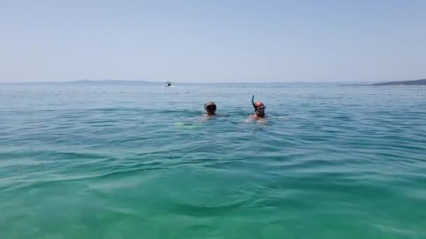 Sporty casal mergulho no mar azul com máscaras e snorkels — Vídeo de Stock