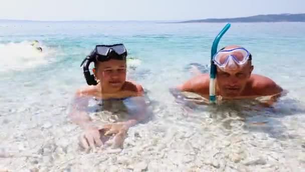 Gelukkige familie genieten van watersporten aan zee — Stockvideo