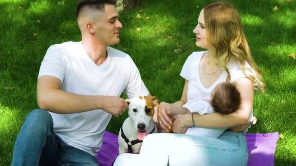 Pečující rodina s dětskou a psí trávení volného času v letním parku — Stock video