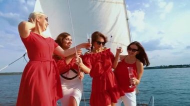 Dört güzel kadın yelkenli teknede şarap ile parti yapıyor