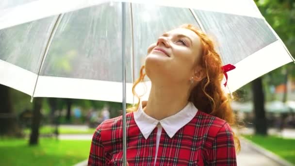 Gioiosa ragazza dai capelli rossi che cammina nel parco soleggiato con ombrello — Video Stock