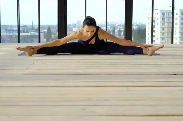 Bella ragazza in abbigliamento sportivo pratica pilates grande studio di yoga — Foto Stock
