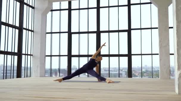 Chica atlética en forma de estiramiento en estudio moderno con grandes ventanas — Vídeos de Stock