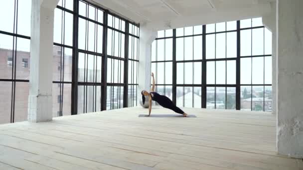 Deportiva chica delgada haciendo tablón lateral en el estudio — Vídeos de Stock