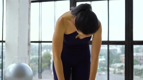 Belle brune en tenue de sport pratiquant dans un grand studio de fitness — Video