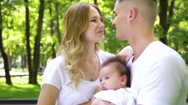 Ευτυχισμένη νέα οικογένεια με το μωρό περνούν το καλοκαίρι στο πάρκο — Αρχείο Βίντεο