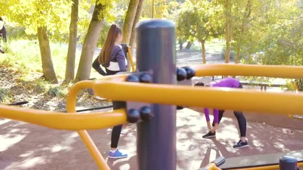 Спортивные девушки, растянувшиеся на спортивной площадке перед бегом — стоковое видео