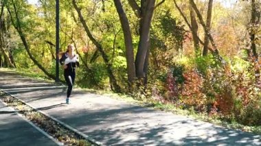 Sonbaharda şehir parkında koştuktan sonra ara veren çekici fit kız.