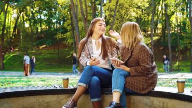 Çevrimiçi bankacılık için akıllı telefon kullanan neşeli kızlar