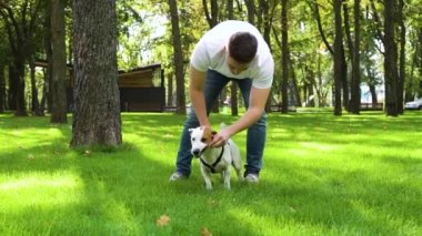 Genç adam, yoldaş köpek Jack Russell ile dışarıda eğleniyor.