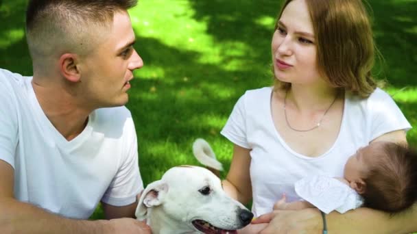 Liefdevol koppel met baby en hond Jack Russell Terrier brengt dag in park door — Stockvideo