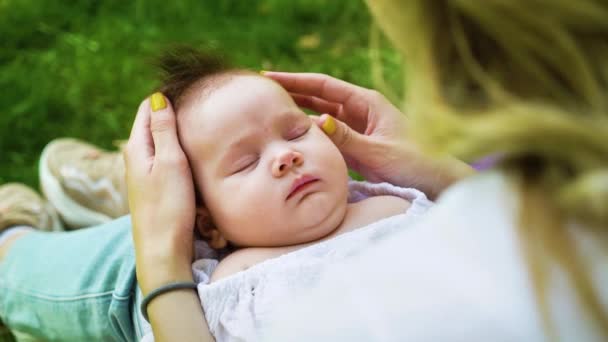 Bakıcı anne dışarıda uyuyan çocukla vakit geçiriyor. — Stok video