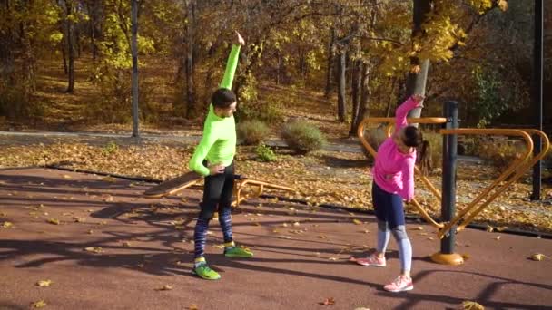 Gelukkig paar doen stretching oefeningen op sportveld in de herfst — Stockvideo