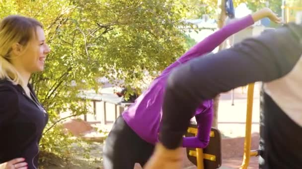 Black girl doing exercises on sports ground with her friends — Stock Video