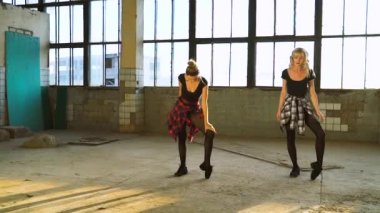 Güzel dansçılar eski fabrika binasında ısınıyor.