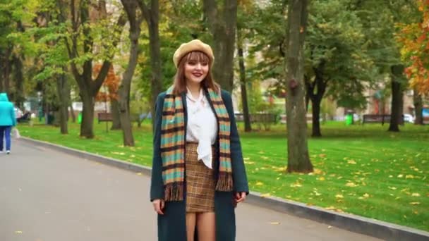 Chica sonriente en traje elegante caminando en el parque de otoño — Vídeos de Stock