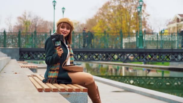 Chica elegante vlogger grabación de vídeo en el parque utilizando el teléfono inteligente con steadicam — Vídeos de Stock