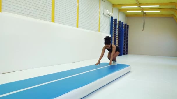 Фигуристка делает сальто на тренировке акробатов в спортзале — стоковое видео