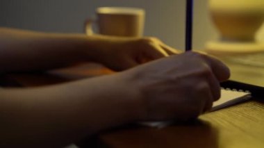 Bilgisayardan öğretmenle çevrimiçi kursa not alan öğrencilerin elleri