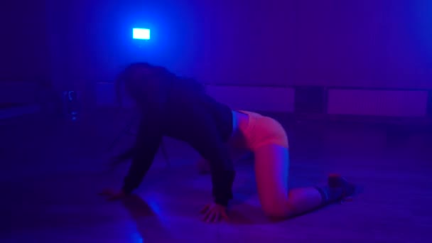 Sexig brunett skakar skinkor medan twerking i mörk studio på golvet — Stockvideo