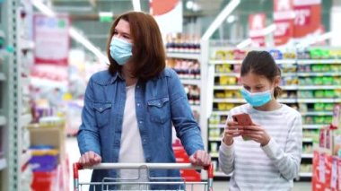 Anne ve kızı salgın sırasında süpermarkette alışveriş yapıyorlar.
