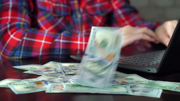 Готівкові гроші падають на стіл працівника, використовуючи ноутбук в офісі — стокове відео