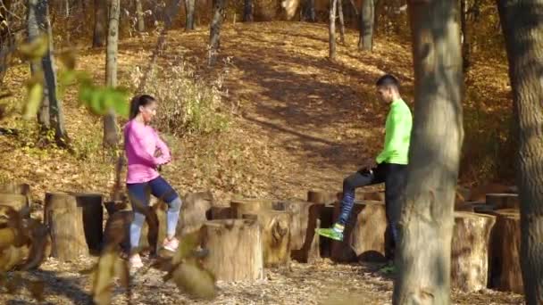 Щаслива спортивна пара тренування в осінньому лісі — стокове відео