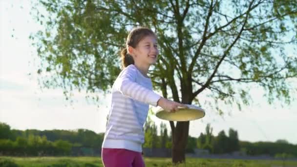 Aktiv flicka lära sig att kasta plast skiva i parken — Stockvideo