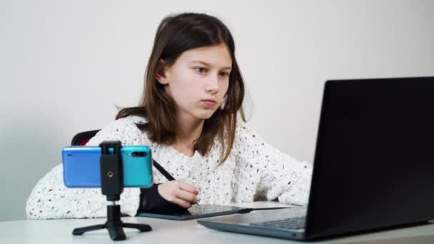 Σοβαρό κορίτσι σχέδιο σε tablet γραφικών, ενώ βλέποντας σε απευθείας σύνδεση μάθημα στο σχεδιασμό — Αρχείο Βίντεο