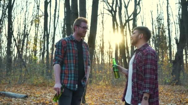 Turistas do sexo masculino bebendo cerveja e começando a lutar na floresta de outono — Vídeo de Stock